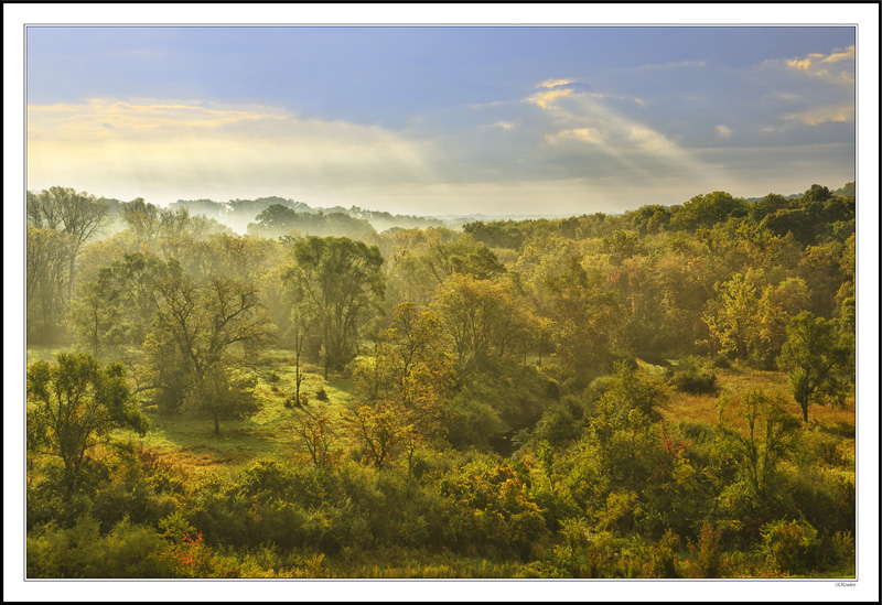 Cloud Breaks Bathe Hazy Sunlight On The Wooded Valley