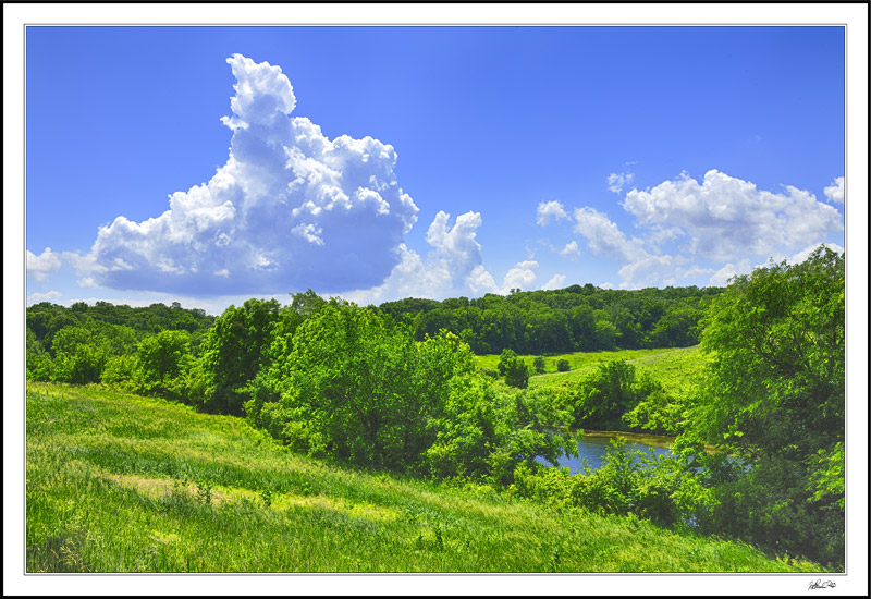 Verdant Lands Beneath Billowing Clouds